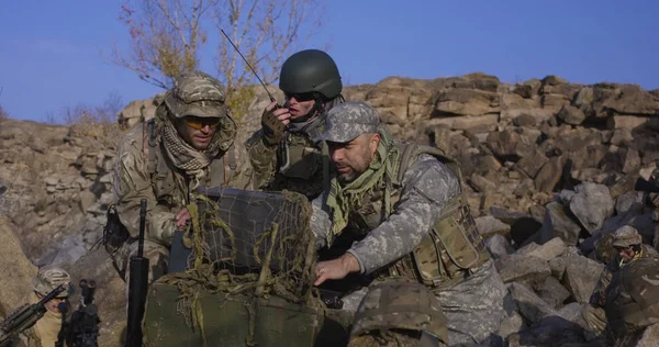 Bewaffnete Soldaten schauen auf einen Computer — Stockfoto