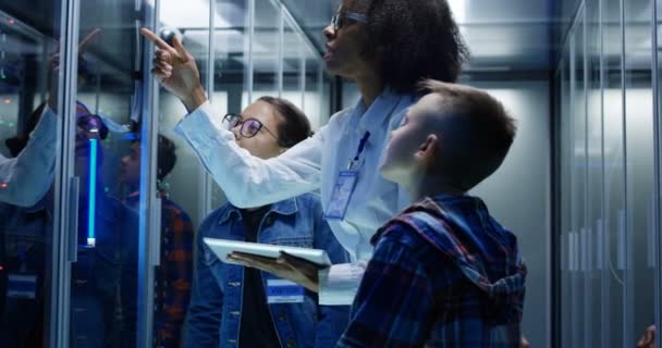 Técnico femenino mostrando alrededor de los niños en un parque de servidores — Vídeos de Stock