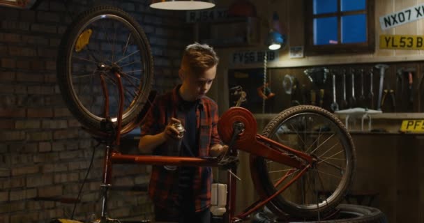 Αγόρι επισκευή ένα ποδήλατο σε ένα γκαράζ — Αρχείο Βίντεο