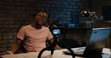 Bir garajda fotoğraf makinesinde konuşan genç adam