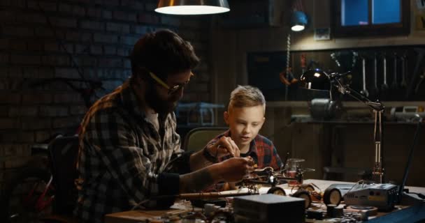 Отец и сын ремонтируют дрон — стоковое видео
