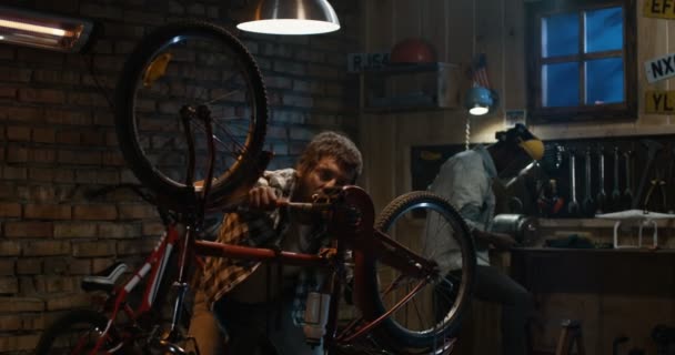 Zwei Mechaniker reparieren ein Fahrrad — Stockvideo
