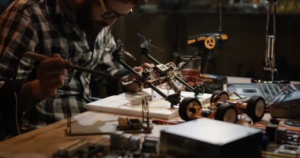 Man soldering drone in a garage — Stock Video