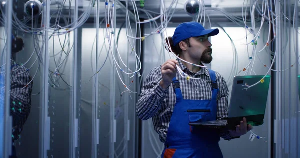Technician checking cables in a data center