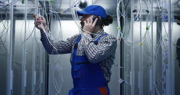 Technician works talking on phone in data center