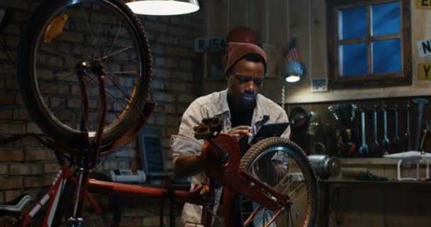 Homme travaillant dans un atelier de réparation de vélos — Video