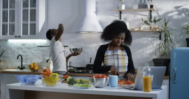 Joven hombre juguetonamente burlas esposa en la cocina — Vídeos de Stock