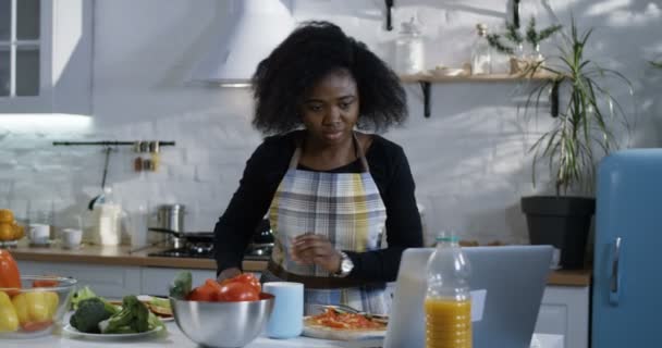 Jovem mulher preparando comida na cozinha — Vídeo de Stock