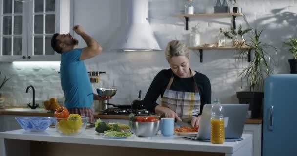 Пара готовит еду вместе на кухне — стоковое видео