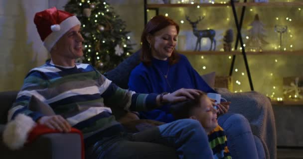 Famille regardant la télévision à la veille de Noël — Video