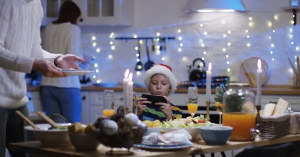 Niño usando el teléfono celular en la víspera de Navidad — Vídeo de stock