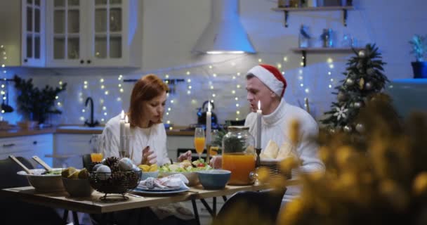 Pareja hablando y comiendo en la mesa de Navidad — Vídeos de Stock