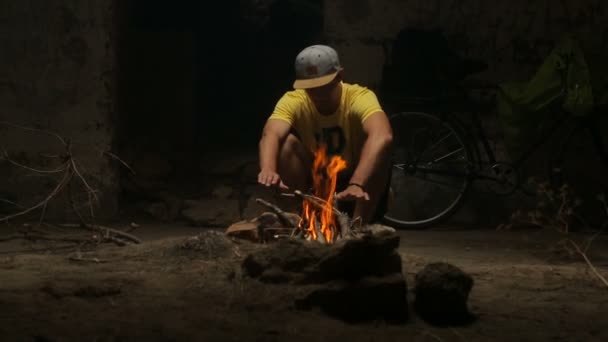 照顾篝火的年轻人 — 图库视频影像