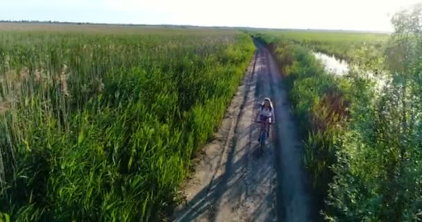 Drönarvy kvinna Rider cykel på landsbygden — Stockvideo