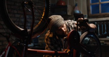 İki adam bir bisiklet tamir dükkanında çalışan