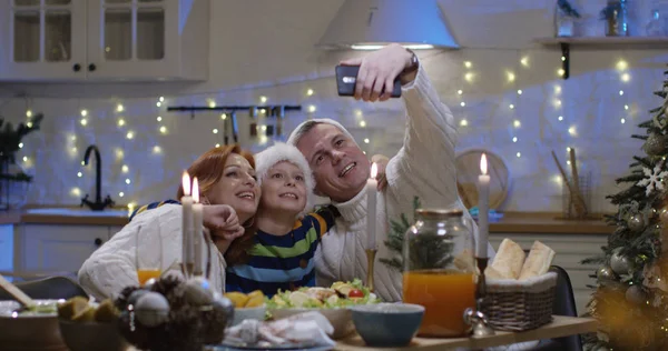 Familie kijken naar foto's aan Kerstmis tafel — Stockfoto