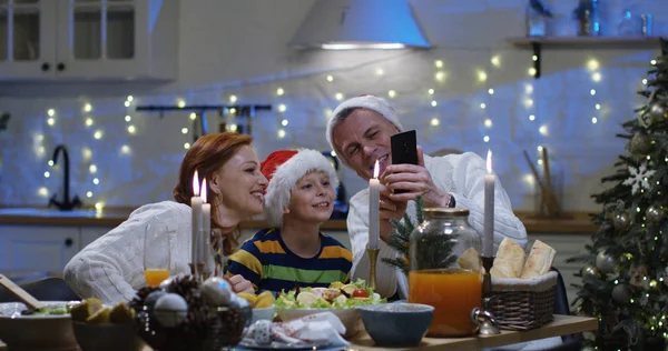 Οικογένεια βλέποντας φωτογραφίες στο χριστουγεννιάτικο τραπέζι — Φωτογραφία Αρχείου