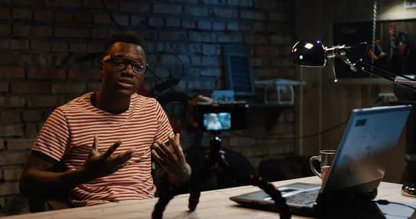 Bir garajda fotoğraf makinesinde konuşan genç adam