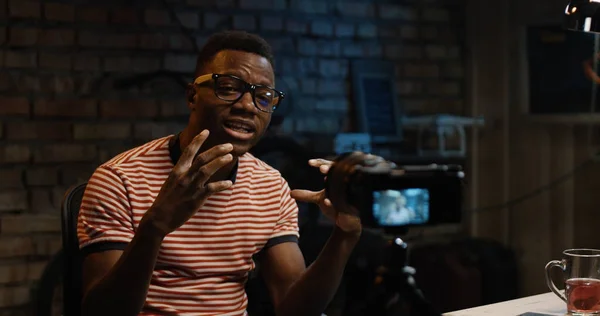 Bir garajda fotoğraf makinesinde konuşan genç adam