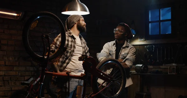 Dois homens conversando em uma oficina de bicicletas — Fotografia de Stock