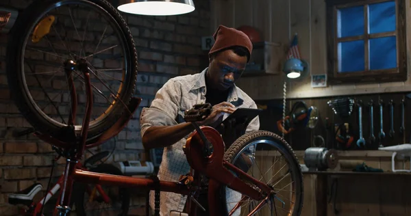 Homem que trabalha em uma oficina de reparação de bicicletas — Fotografia de Stock