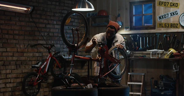 Hombre que trabaja en un taller de reparación de bicicletas — Foto de Stock