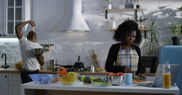 Jovem brincalhão provocando esposa na cozinha — Fotografia de Stock