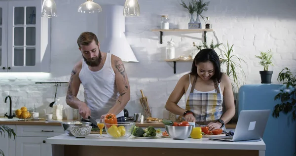 Casal cortando legumes na cozinha — Fotografia de Stock