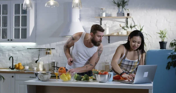 Casal cortando legumes na cozinha — Fotografia de Stock