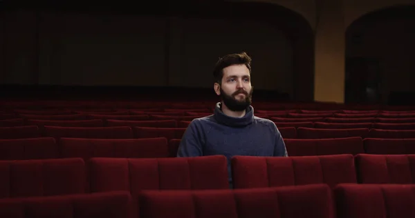 Man watching a theater performance alone