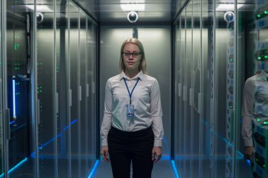 Veri merkezinin koridorda gülümseyen mühendisi