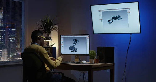 Jeune homme assis et éditant un modèle 3D sur son ordinateur — Photo