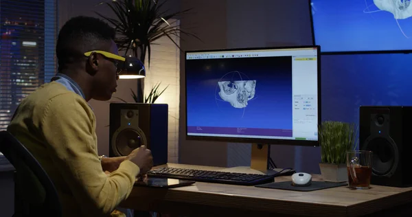 Jovem sentado e editando uma imagem em seu computador — Fotografia de Stock