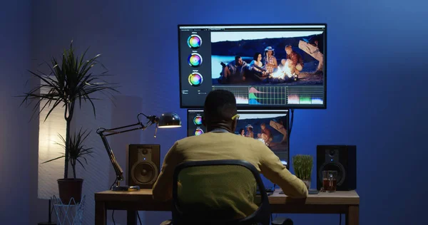 Giovane uomo seduto e modificare un video all'interno di una stanza — Foto Stock