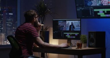 Genç adam arka oturma ve bir oda içinde video düzenleme