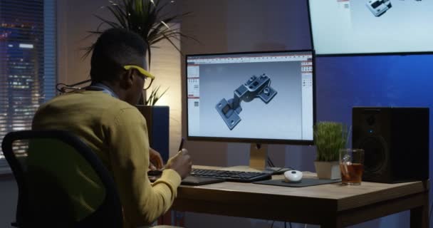 Young man siiting back and editing an image on his computer — Stock Video