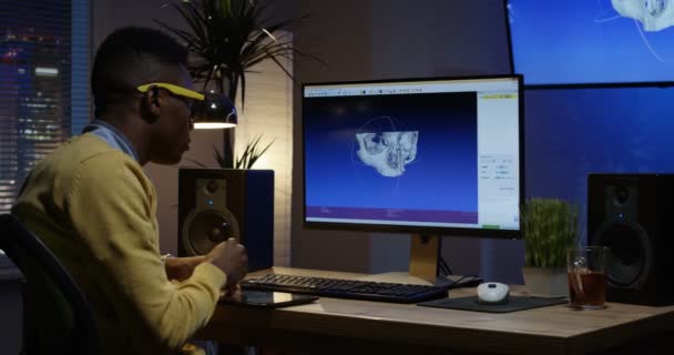 Young man sitting back and editing an image on his computer — Stock Video