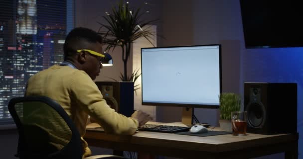Młody mężczyzna siedzi z powrotem i pracę w pomieszczeniu — Wideo stockowe