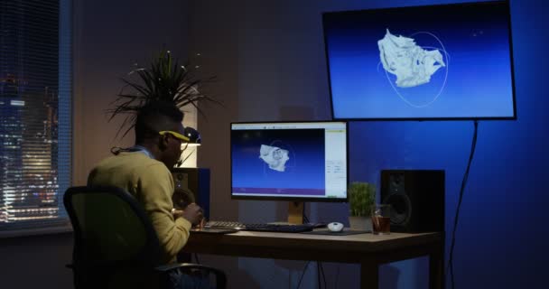 Νεαρός κάθεται πίσω και να επεξεργάζεστε μια εικόνα στον υπολογιστή του — Αρχείο Βίντεο