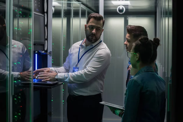 IT technician typing in server park with children