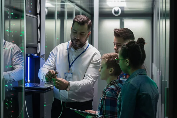 Técnico de TI mostrando cable a los niños — Foto de Stock