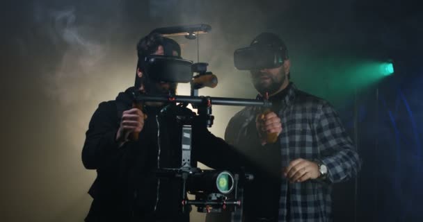 Операторы в очках виртуальной реальности, работающие на съемочной площадке — стоковое видео