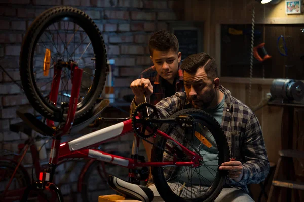 Ojciec i syn mówi o naprawy rowerów — Zdjęcie stockowe