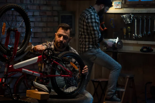 Due uomini che lavorano in un negozio di riparazione di biciclette — Foto Stock