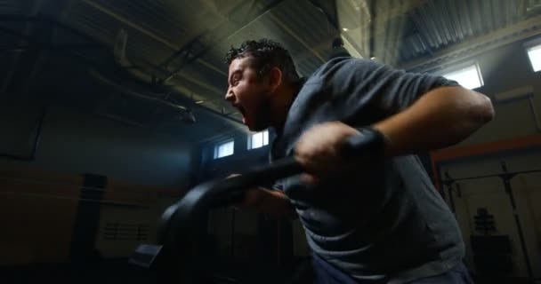 Surpoids jeune homme faisant de l'exercice avec une machine — Video