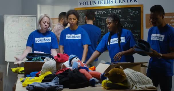 Equipe de voluntariado embalando roupas — Vídeo de Stock