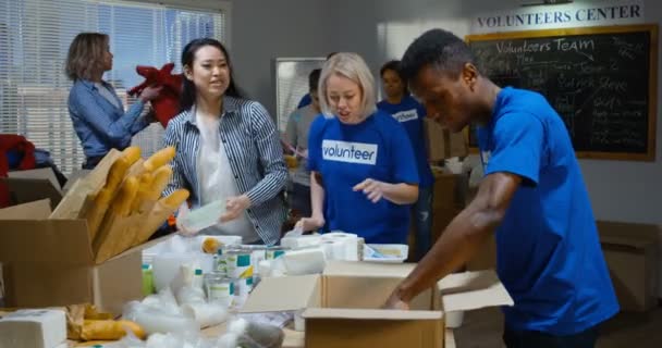 Freiwilliges Team packt gespendete Lebensmittel ein — Stockvideo