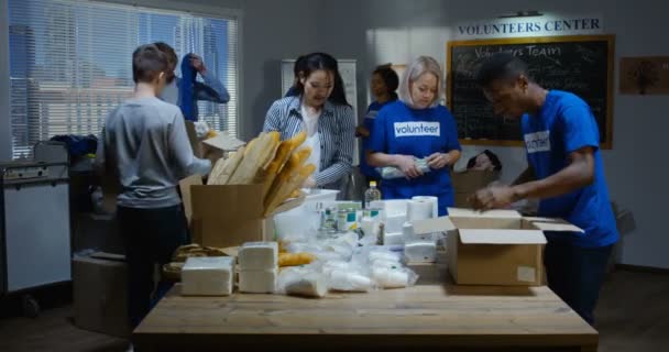 Команда волонтеров собирает пожертвованные продукты питания — стоковое видео
