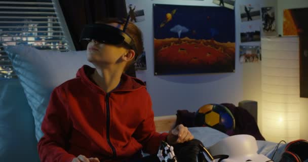 Хлопчик використовує гарнітуру віртуальної реальності вдома — стокове відео