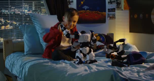 Мальчик играет с игрушечным роботом — стоковое видео